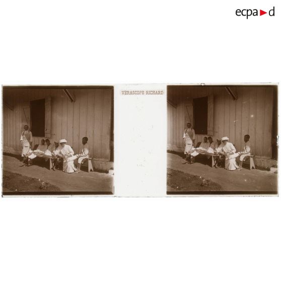 [Hôpital militaire de Rabat : une infirmière administre des soins à des blessés devant une baraque].<br> [Légende d'origine]