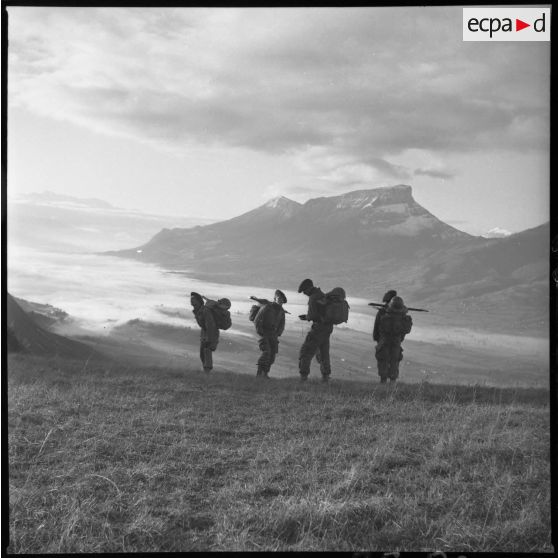 Rallye. Arrivée au-dessus de Challes-les-Eaux. Sandon, Benko, Petitot Gérard, Santos-Cottin, tous appelés 60/2A au 13e BCA. Après une nuit glaciale, retour à la caserne Barbot par un beau soleil sur une mer de nuage au-dessus de Challes-les-Eaux et Chambéry. Superbe ! Octobre 1960. [légende d'origine]