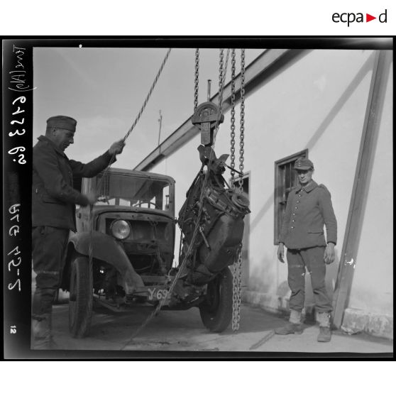 Des prisonniers de guerre allemands déposent un moteur, dans l'atelier fixe des Issers.