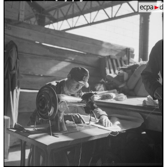 Portrait d'un garnisseur allemand à la machine à coudre, dans les ateliers fixes des Issers.