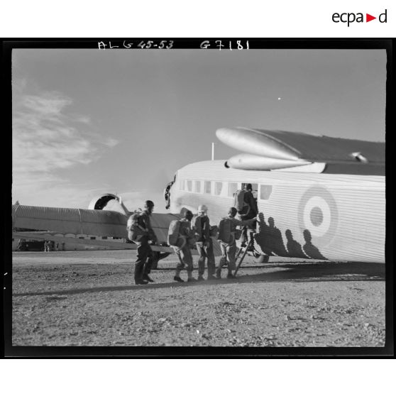 Des parachutistes montent à bord d'un avion de transport.