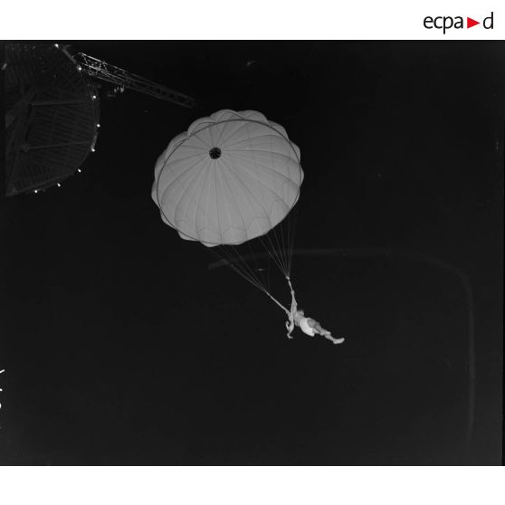 Vue en contre-plongée d'un saut en parachute, depuis une tour.