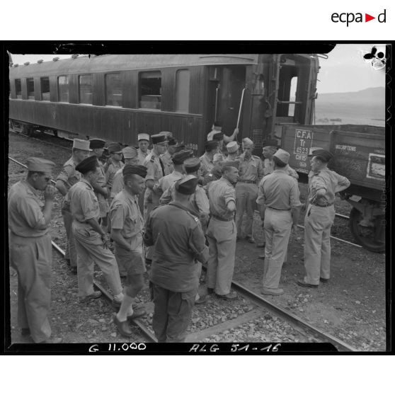 Officiers et éléments d'un régiment d'infanterie devant un wagon dans la région de Tebessa.