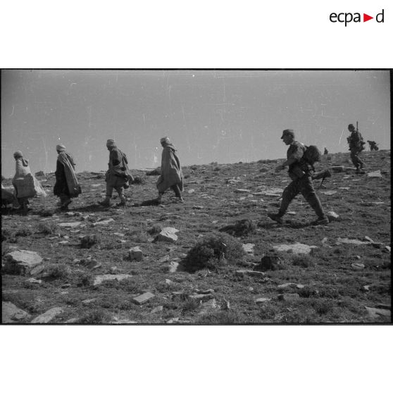 [Soldats en patrouille et civils].