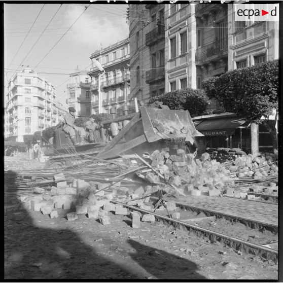 Janvier 1960 - un bulldozer du Génie détruit une barricade rue Michelet. [légende d'origine]