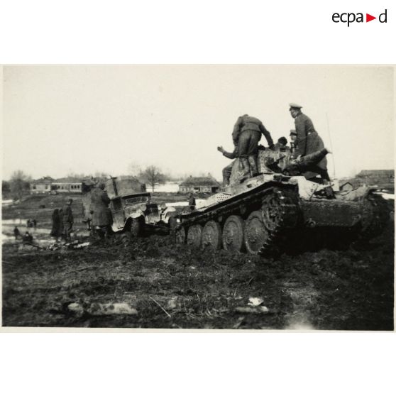 [Sur les routes détrempées du front de l'Est, un blindé léger Panzer 38 (t) tracte un camion SIS-5 d'origine soviétique].