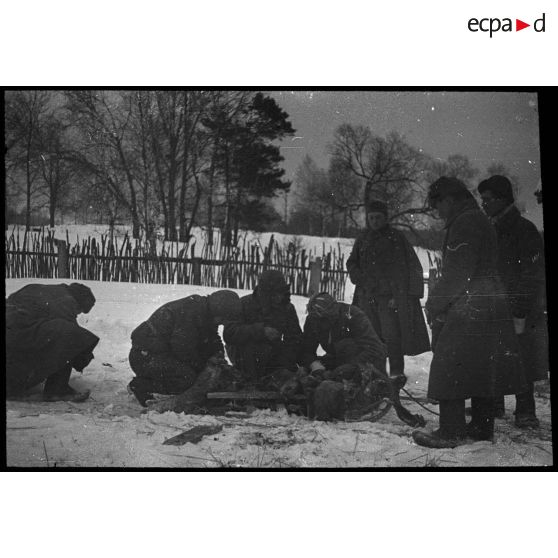 Medyn - Woronov. [Un groupe de soldats autour d'un traîneau dans la neige]. [Description en cours]