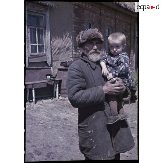 Ljudjnowo - Rhew. [Portrait d'un homme qui porte un enfant dans ses bras]. [Description en cours]