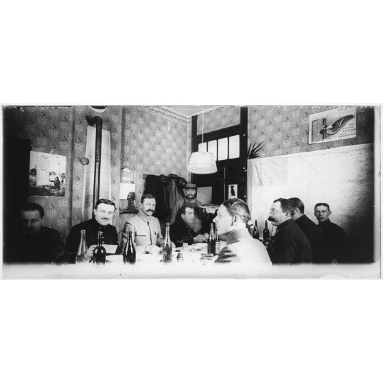 L'escadrille MF 44 prenant son repos. La pose a été longue et l'on aperçoit le plus fou de la table qui n'a pas pu tenir son sérieux pendant plus de 7 secondes. Heureusement le mal n'est pas grand et son accès de fou rire passe presque inaperçu. [légende d'origine]
