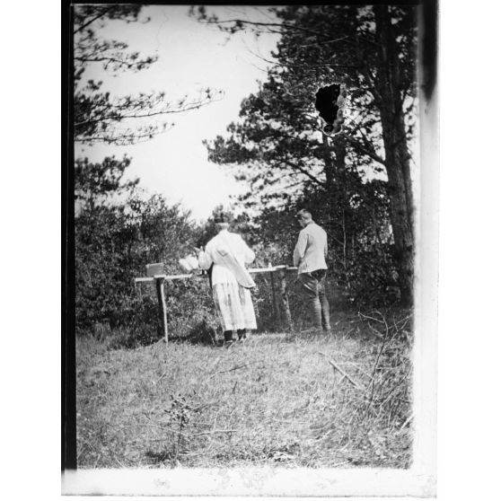 [Prêtre disant la messe sur un autel de campagne en rondins en extérieur].