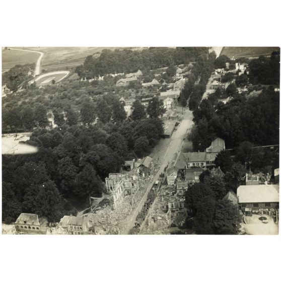 [Photographie aérienne du cortège d'un enterrement dans une ville en ruine].