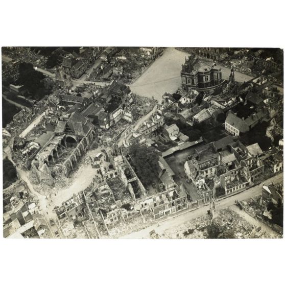 [Photographie aérienne du cortège d'un enterrement dans une ville en ruine].