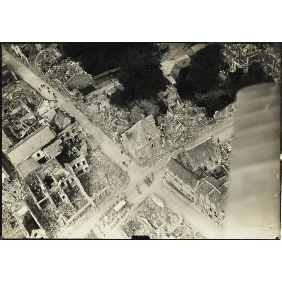 [Photographie aérienne du cortège d'un enterrement dans une ville en ruine].