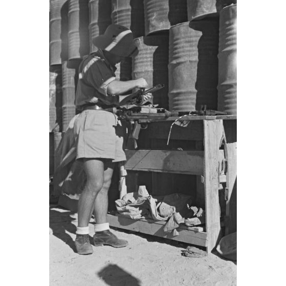 Sous l'aile d'un Stuka, un mécanicien effectue la maintenance d'une mitrailleuse MG-81 qui équipe les Junkers Ju-87 du Sturzkampfgechwader 3.
