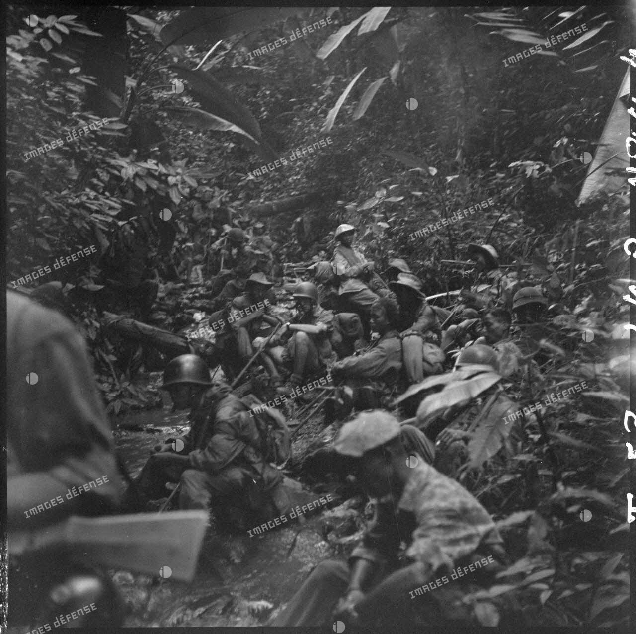 Des parachutistes de la colonne Langlais font une halte au bord d'un ruisseau en plein jungle, au cours de leur progression vers le Laos.