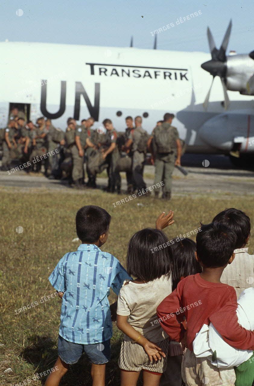 Les enfants cambodgiens saluent les soldats français qui embarquent à bord d'un Hercule C-130.