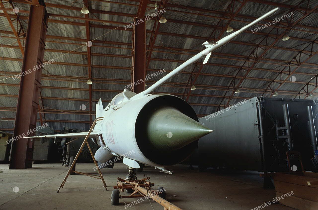 Avions à réaction Fishbed version B au sol entreposés dans un hangar.