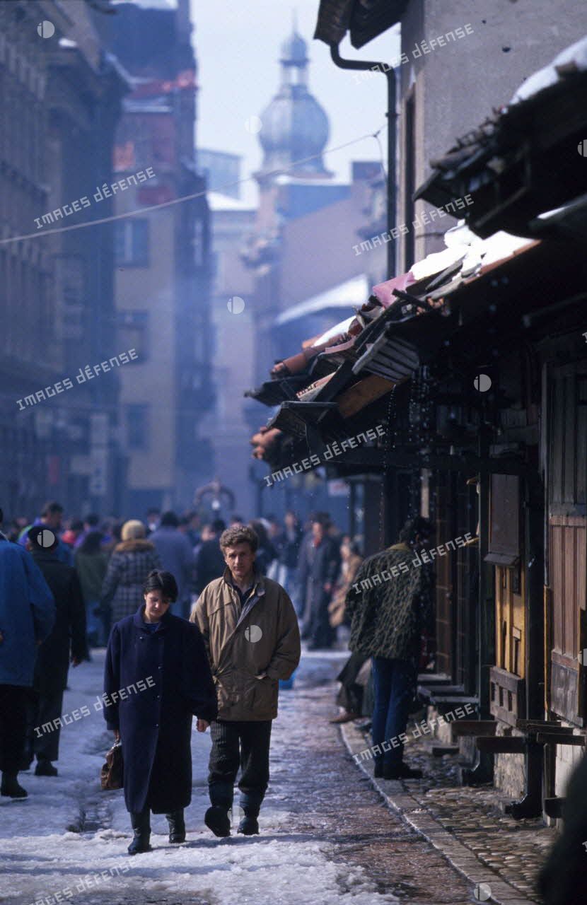 Des passants se promènent dans une ruelle de Sarajevo.