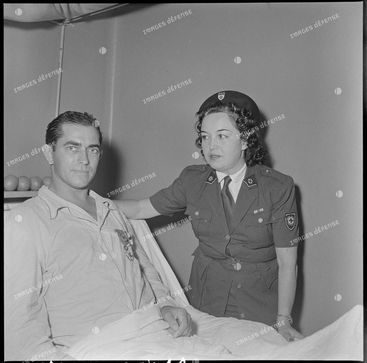 L'adjudant-chef Bartier pose avec un personnel de la Croix-Rouge française (CRF) après sa décoration de la Légion d'honneur et de la Croix de guerre des TOE par le général Dechaux à l'hôpital Lanessan.