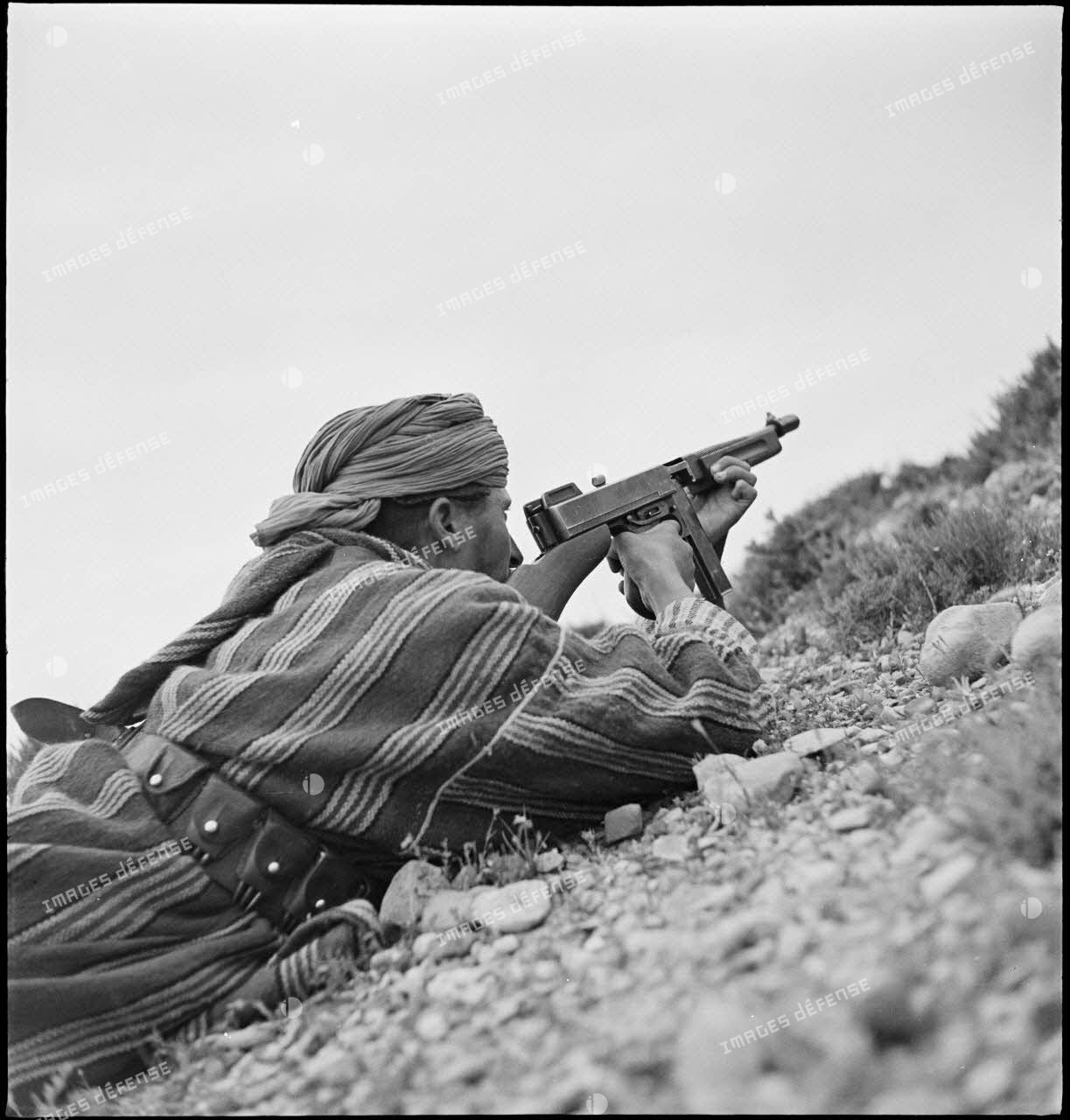 Un goumier du IIe Tabor du 1er GTM (groupe de tabors marocains) de la 1re DMM (division de marche du Maroc), posté dans le secteur d'Ousseltia, utilise un pistolet mitrailleur Thompson M1.