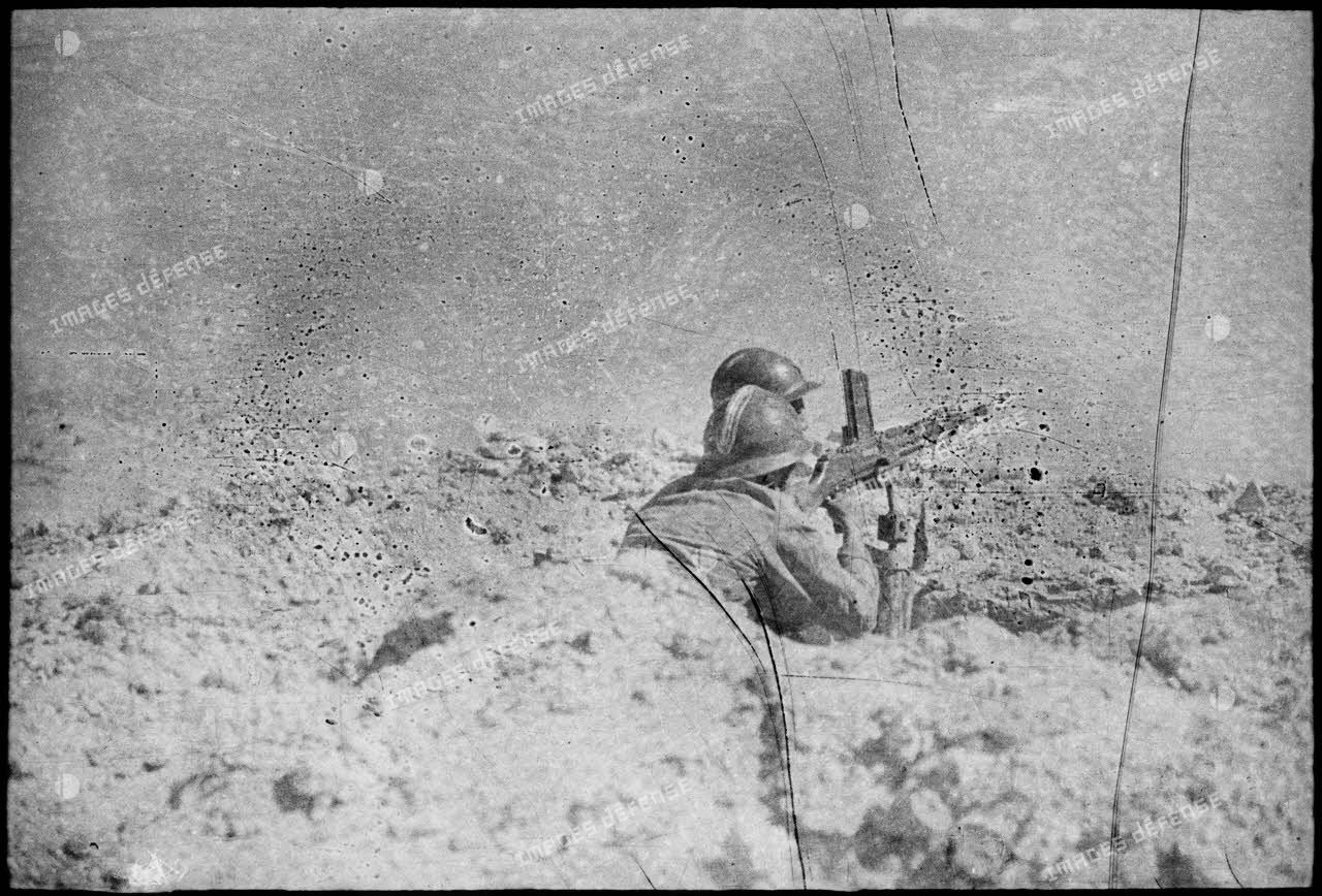 Soldats du FSEA (Front sud-est algérien), servants d'un fusil-mitrailleur FM 24/29, en position de tir dans un trou individuel en premières lignes, dans le désert au nord du Chott el Jerid.
