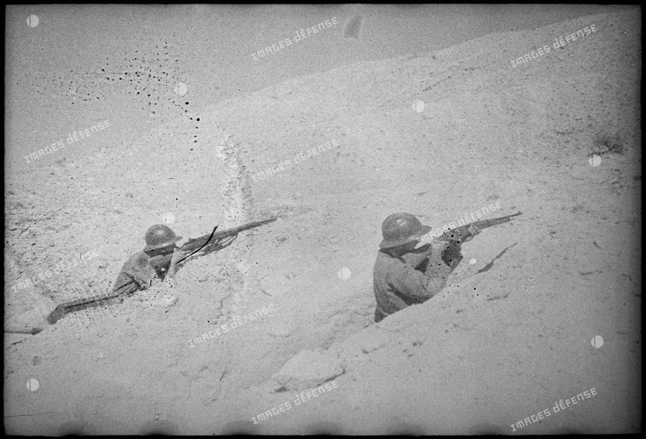 Soldats du FSEA (Front sud-est algérien), en position de tir, postés dans un trou de combat dans les premières lignes au nord du Chott el Jerid.