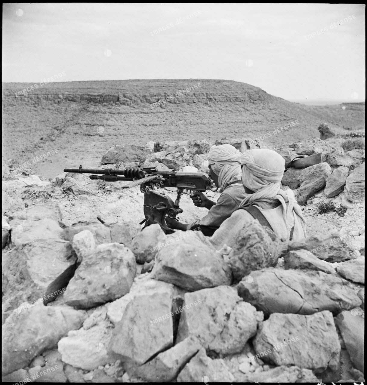 Mise en batterie d'une mitrailleuse Hotchkiss, modèle 1914, par des méharistes du groupement du capitaine Paganelli dans le secteur du FSEA. (Front sud-est algérien), entre le col de Bir el Asker et le Chott el Jerid.