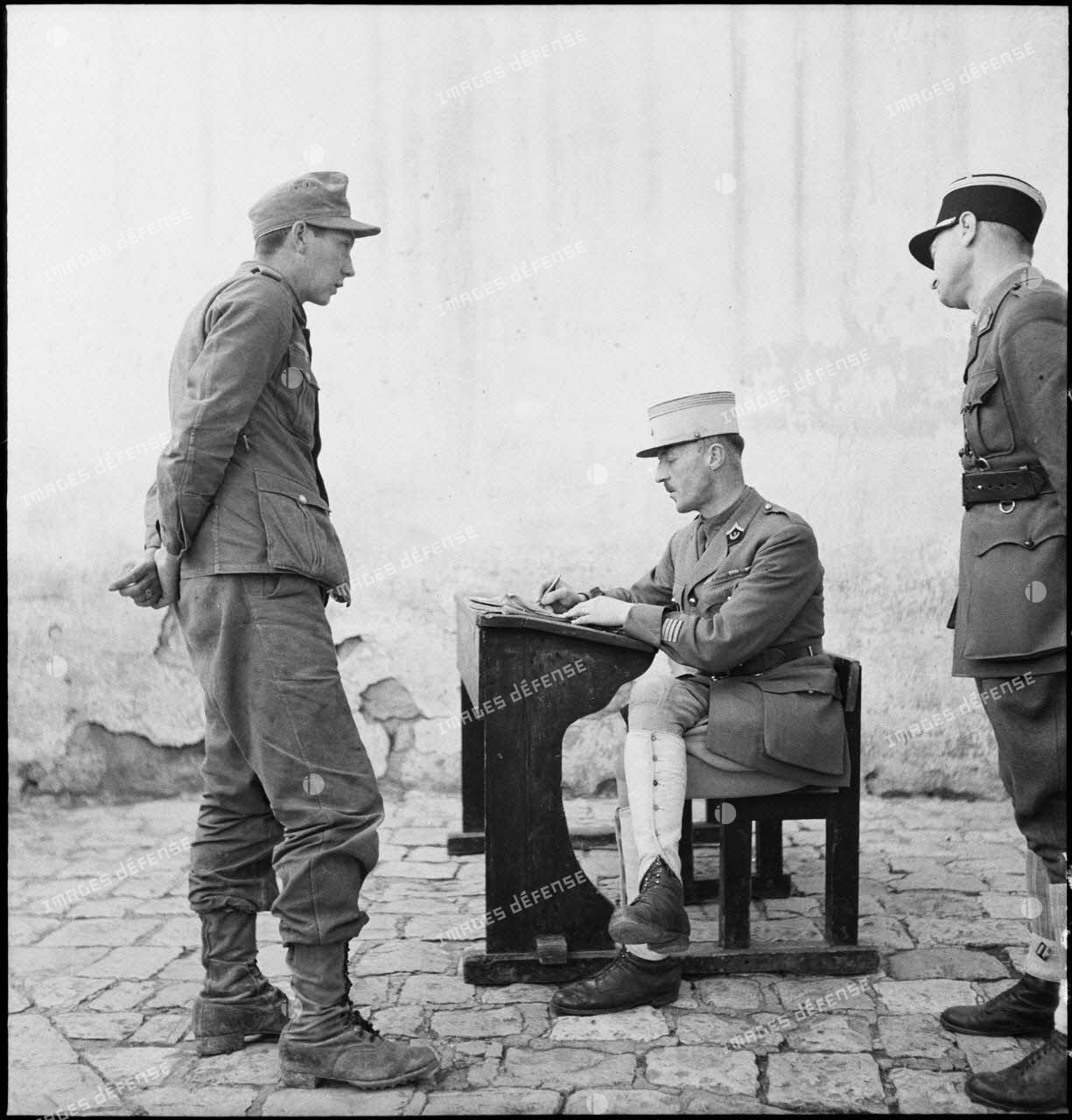 Interrogatoire d'un prisonnier allemand, engagé dans le corps expéditionnaire de l'Afrikakorps, par un chef d'escadrons du 3e RSA (régiment de spahis algériens) de la DMC (Division de marche de Constantine.