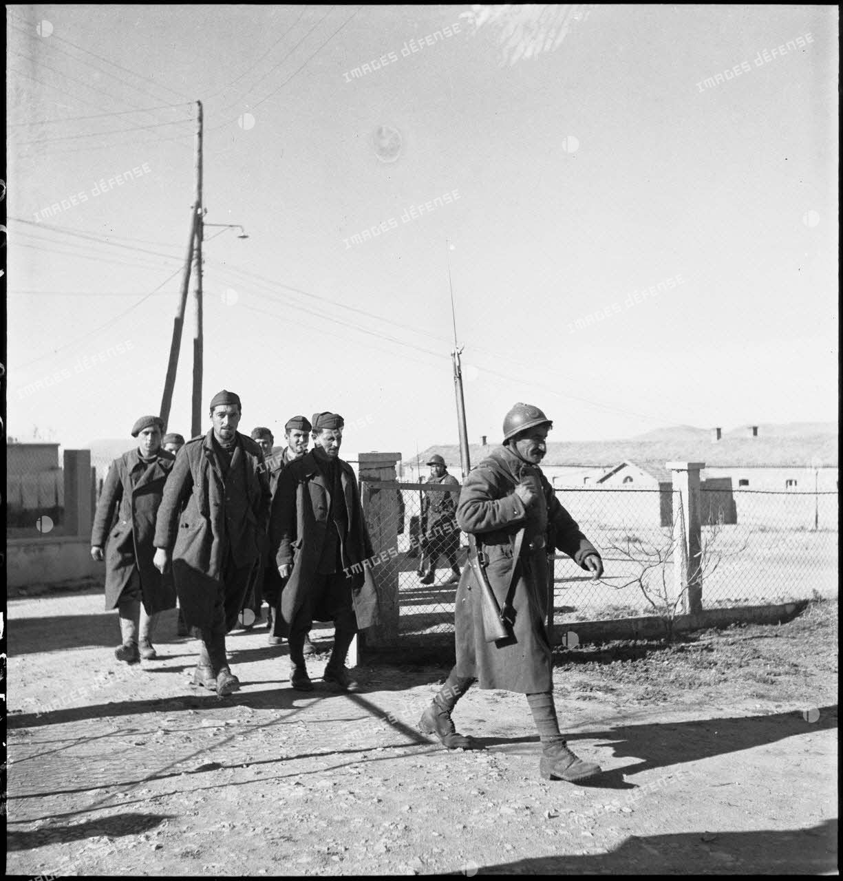 Des prisonniers italiens sont escortés vers un poste de commandement français pour y être interrogés.