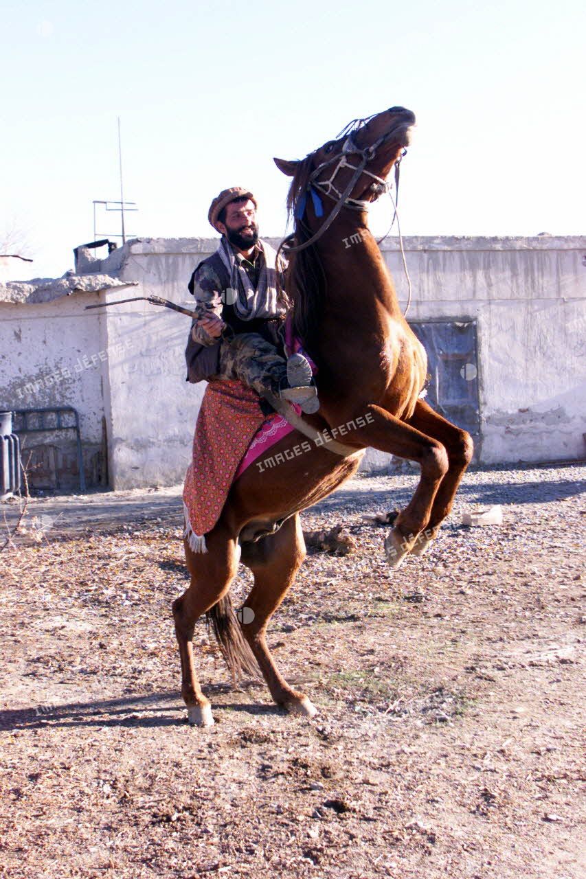 Un soldat afghan gardant un poste de l'aéroport de Kaboul sur son cheval.