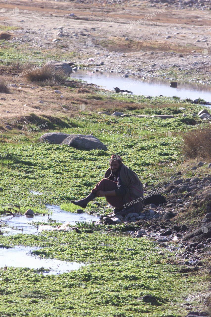 Un homme afghan se lavant dans un ruisseau.