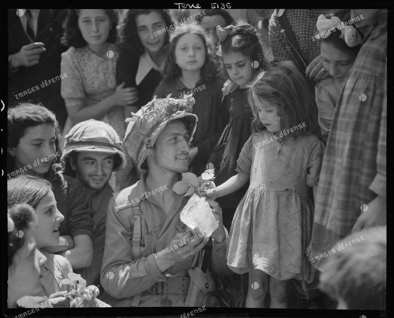 À Colleferro, à quarante kilomètres au sud-est de Rome, une enfant offre des fleurs à un soldat de la 1st special service force (détachement du service spécial) de la 5e armée américaine.