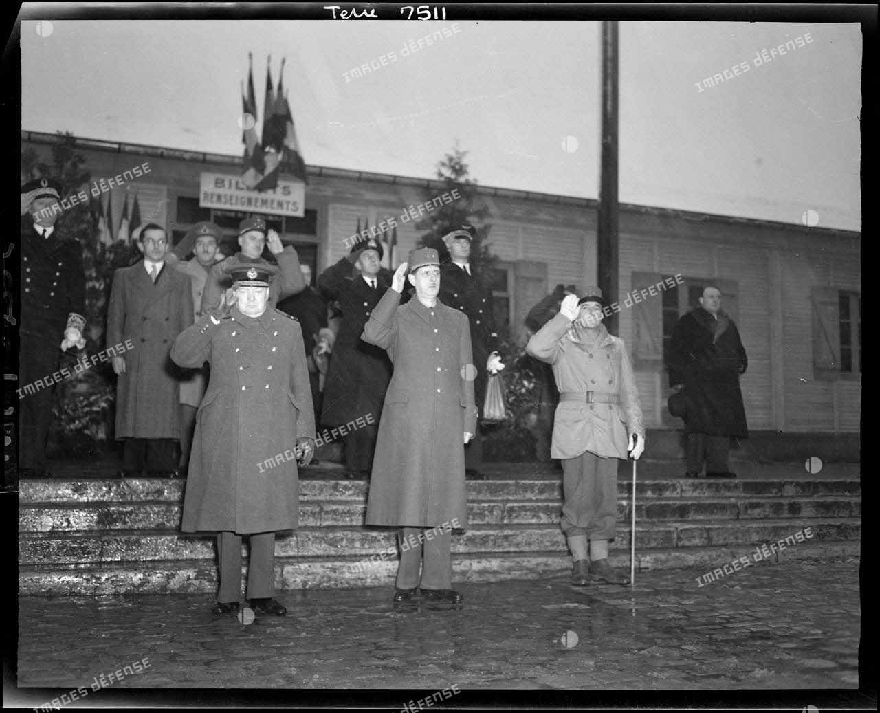 Winston Churchill, le général de Gaulle et le général de Lattre de Tassigny, en gare de Besançon, rendent les honneurs pendant l'exécution des hymnes nationaux.