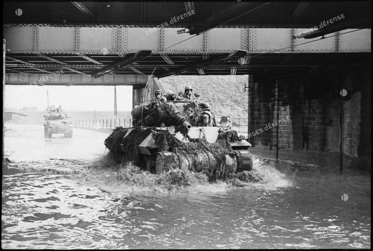 Eléments du GTV, le groupement tactique du colonel de Guillebon, abordant Strasbourg par le faubourg de Cronenbourg envahi par les eaux de l'Ill en crue et passant sous un pont ferroviaire.