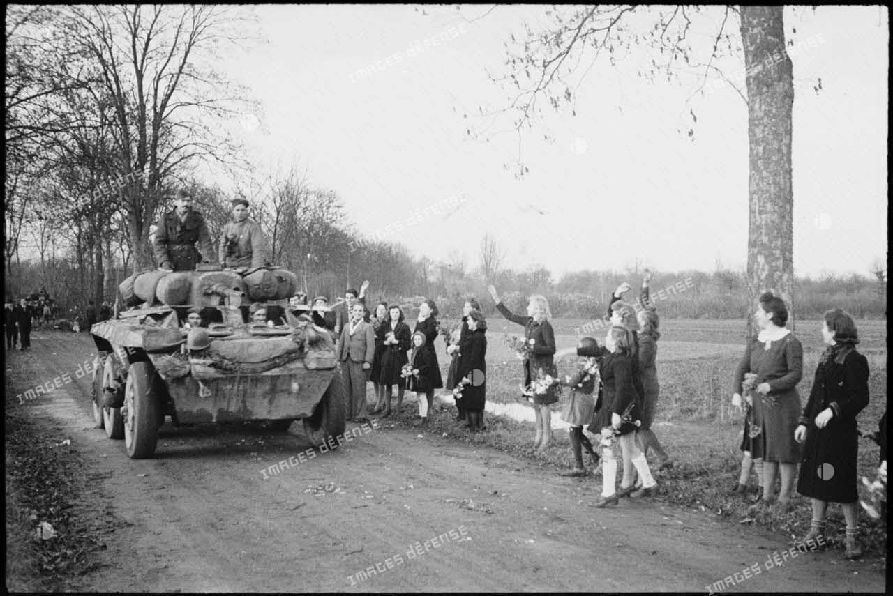 Automitrailleuse M8 du 3e escadron du 1er RMSM acclamée à son passage par la population des villages libérés.
