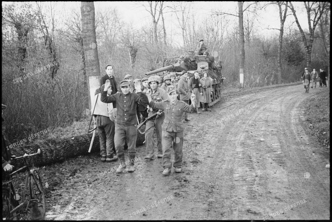 Prisonniers de guerre allemands conduits par des soldats de la 2e DB devant la population des villages libérés.