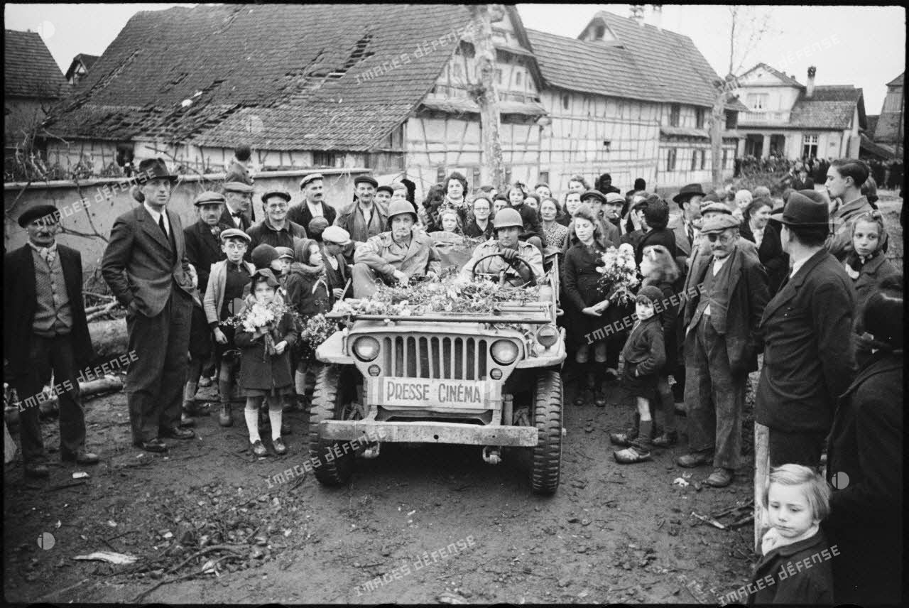 Le 28 novembre 1944, la population d'Hindisheim, libérée par le sous-groupement Rouvillois, accueille une jeep "Presse cinéma" du SCA.<br>
