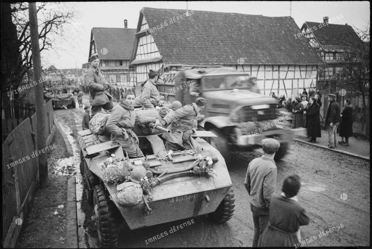 Probablement à Entzheim, une automitrailleuse M8 du 2e peloton du 3e escadron du 1er RMSM, fleurie par la population du village libéré.