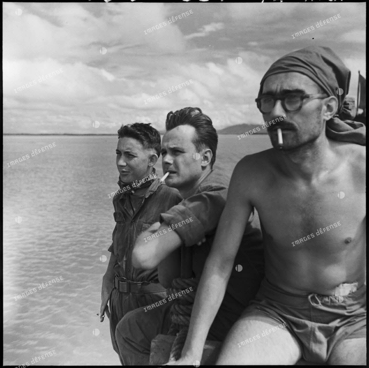Venant d'être libérés d'un camp Viêt-minh, le cameraman du SPI (service presse information) Pierre Schoendoerffer (au centre) et des camarades sont acheminés vers Hanoï à bord d'un LCM (landing craft materiel).