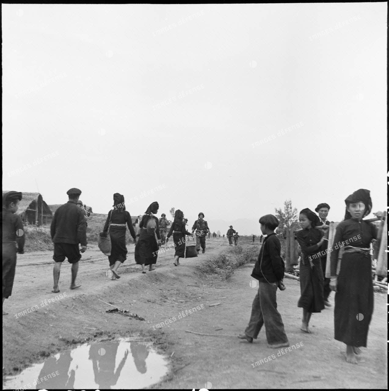 Des troupes parachutées près du camp de Diên Biên Phu traversent un village habité par des Thaï.