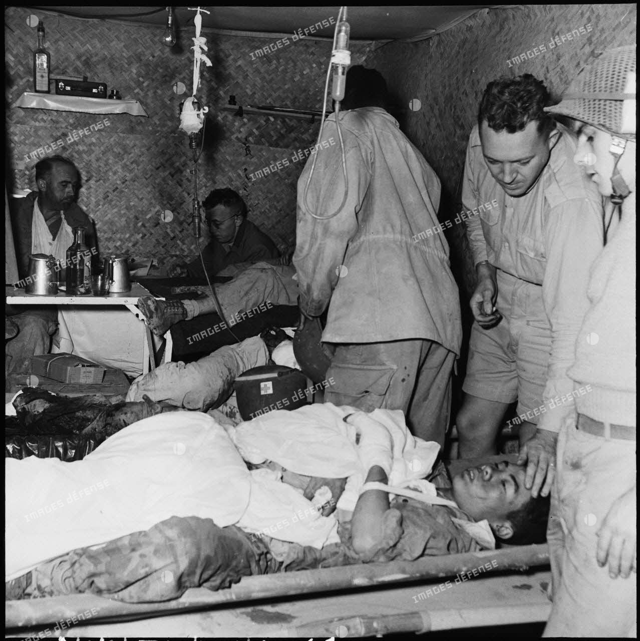 Des blessés reçoivent les premiers soins à l'antenne chirurgicale du camp retranché de Diên Biên Phu, installée sous terre.