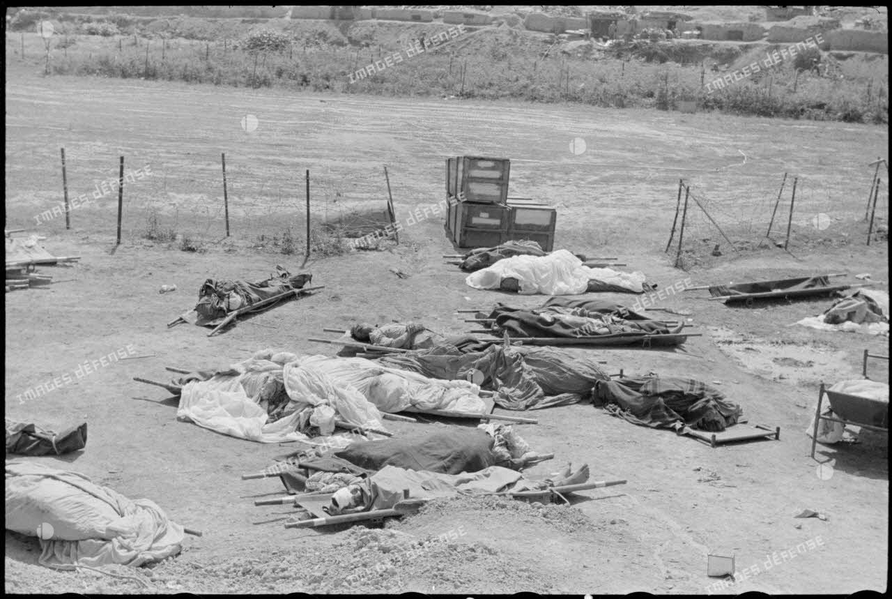 Des cadavres de soldats alignés au sol près d'un point d'appui du camp retranché de Diên Biên Phu.