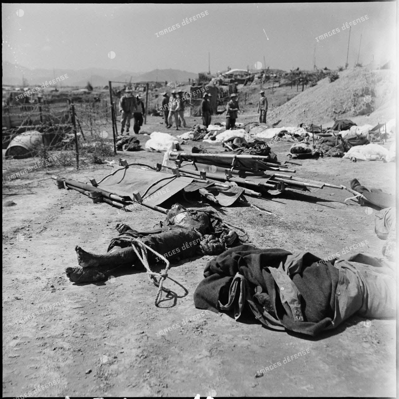 Les corps de soldats morts au combat, emmaillotés ou recouverts d'un tissu, gisent au sol près d'un point d'appui du camp retranché de Diên Biên Phu.