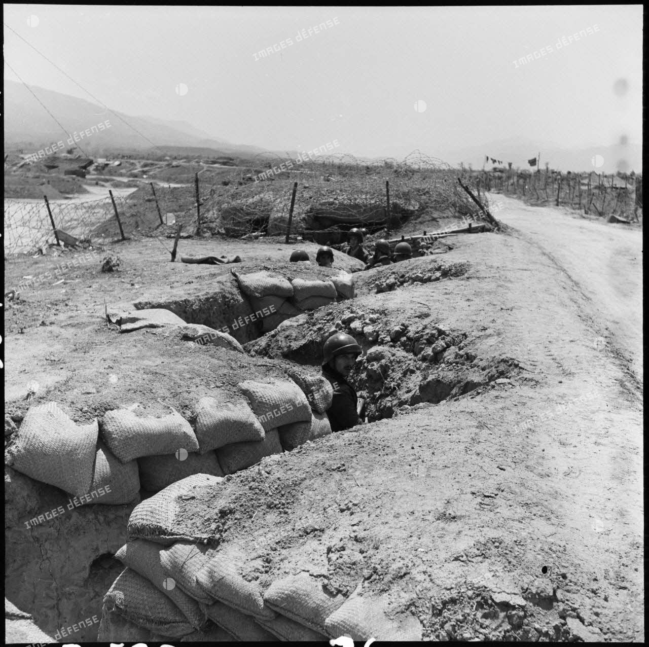 Des soldats dans les boyaux d'une tranchée bordant la route du camp retranché de Diên Biên Phu.
