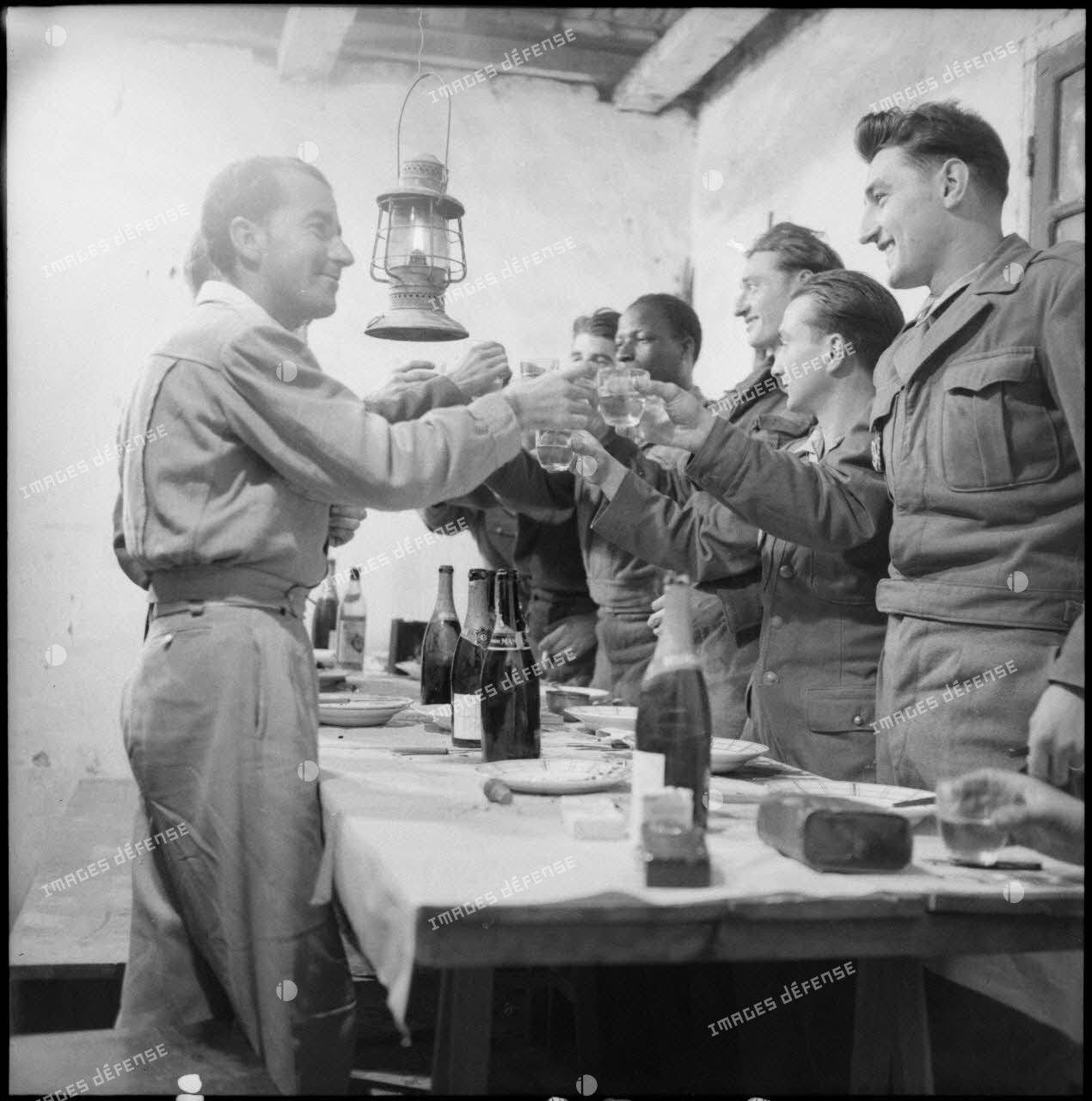 Des soldats d'un poste du delta tonkinois portent un toast pendant leur repas de noël.