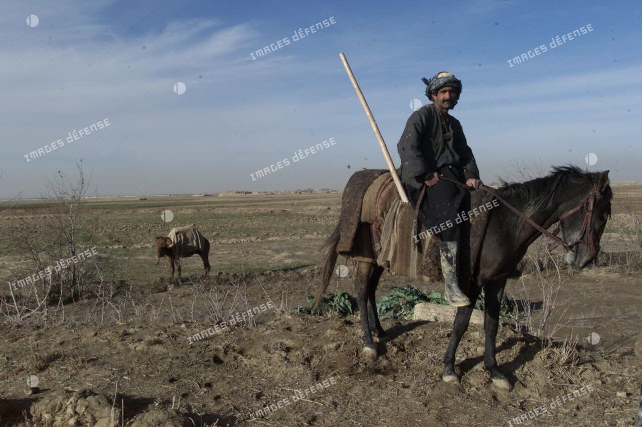 Les Afghans tadjiks du clan du général Ata sécurisent l'aéroport de Mazar e Charif tout en continuant à cultiver les champs aux alentours. Paysan à cheval.