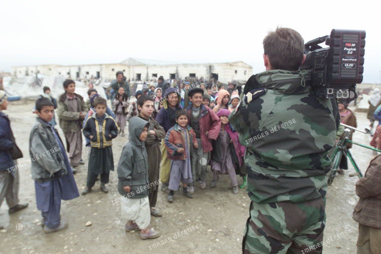 Camp de réfugiés afghans à Mazar e Charif. Le sergent-chef, caméraman de l'ECPAD (Etablissement de communication et de production de la Défense), filme les enfants.
