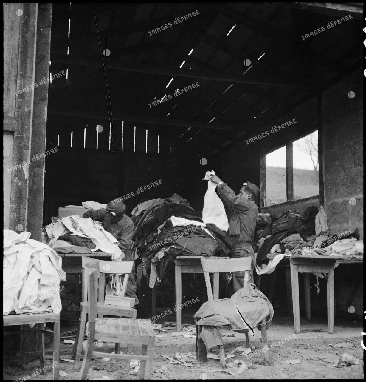 Des soldats français trient des vêtements confisqués à la population civile allemande au profit des déportés libérés du camp de Vaihingen.