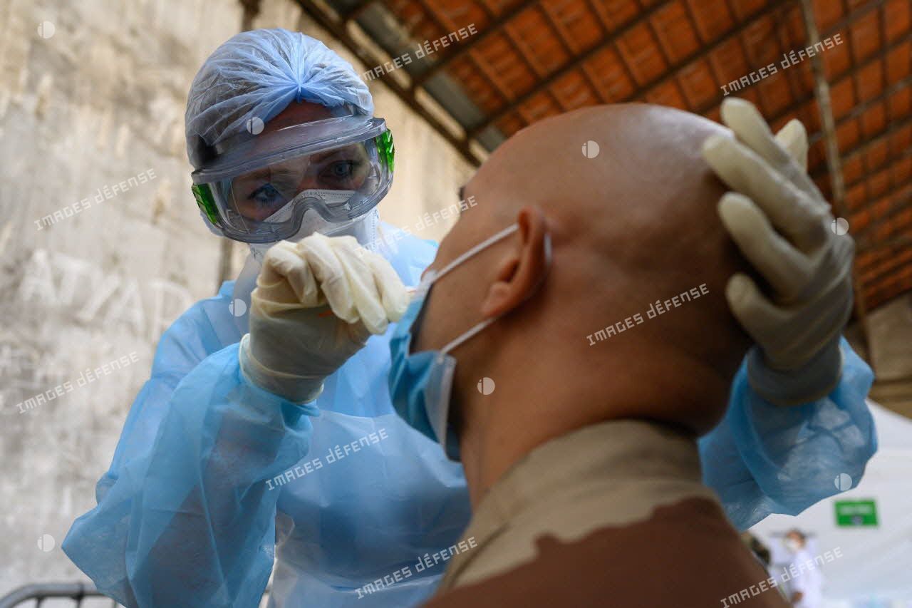 Une infirmière de l'hôpital d'instruction des armées (HIA) Bégin pratique un test de dépistage de la Covid-19 sur un soldat de retour d'opération extérieure.