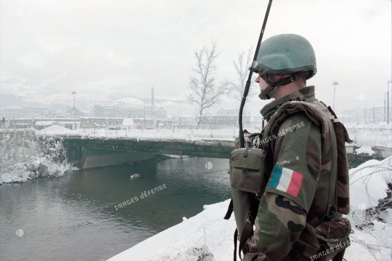 Un casque bleu français assure la protection des piétons de Sarajevo lors de leur passage sur les ponts de la ville.